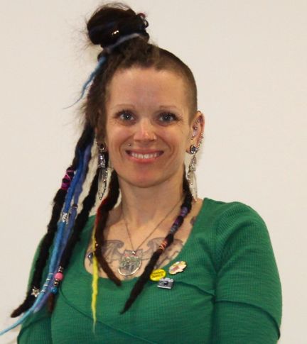 Smiling woman with colourful dreadlocks and a green shirt