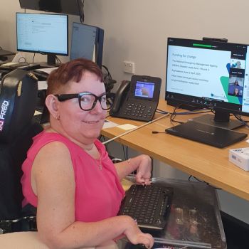 A woman in a power wheelchair using a computer