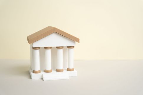 A white figurine of a building with pillars.