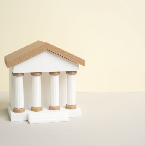 A white figurine of a building with pillars.