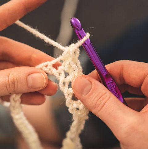 A close up of someone using an ergonomic crochet hook