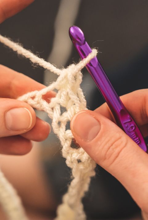 A close up of someone using an ergonomic crochet hook