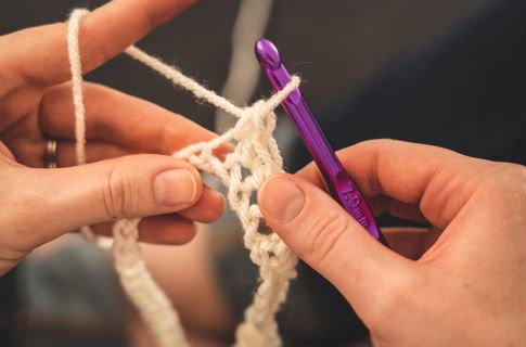 A close up of someone using an ergonomic crochet hook
