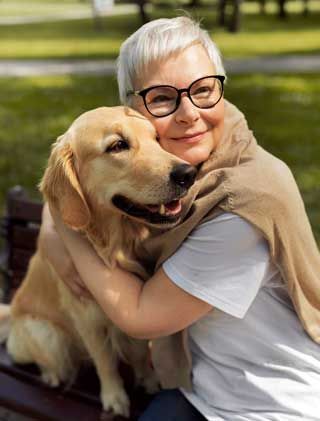 Smiling lady spending time with her dog in the park