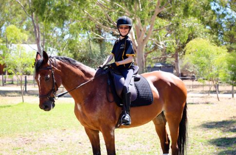 Fluer sitting on a horse on sunny day.