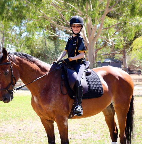 Fluer sitting on a horse on sunny day.