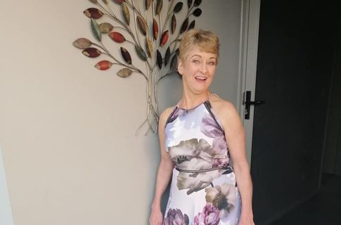 Kerry Ann standing next to artwork smiling.