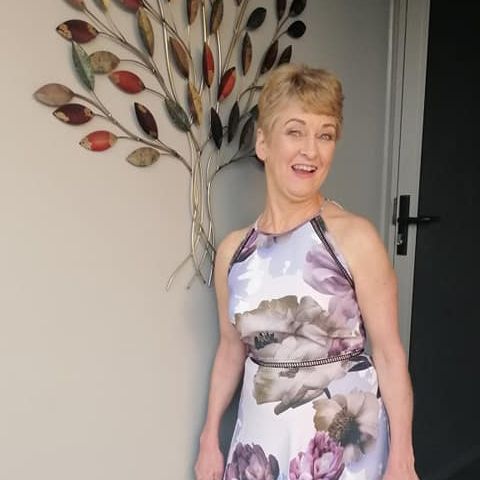 Kerry Ann standing next to artwork smiling.