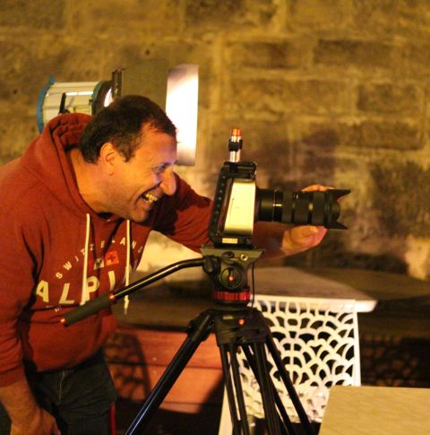 Peter looking through his camera on tripod.