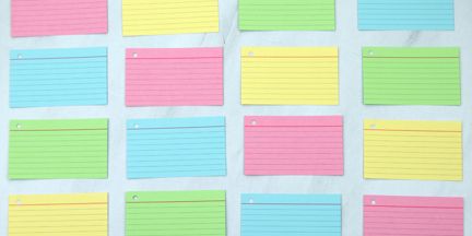 a stone table with colourful, blank index cards laid out