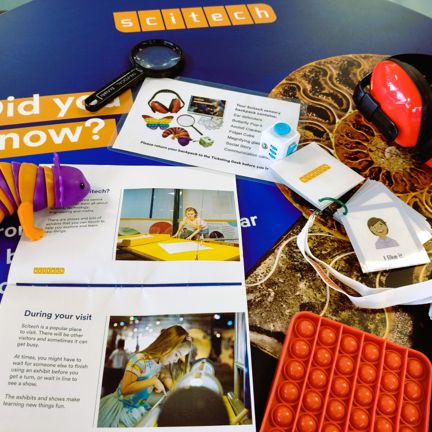 A table with the text 'Scitech' at the top, with an array of items from a sensory kit spread out