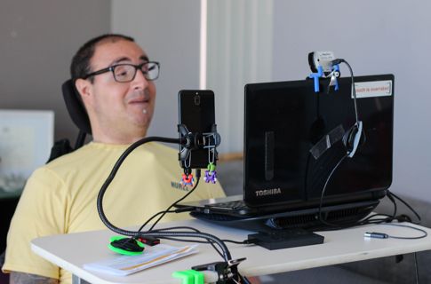 Shane in front of his computer using assistive technology.