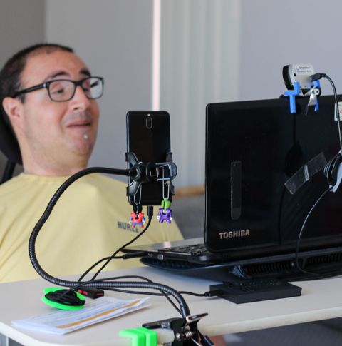 Shane in front of his computer using assistive technology.