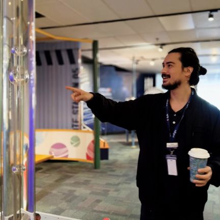 A young man pointing at an exhibit excitedly