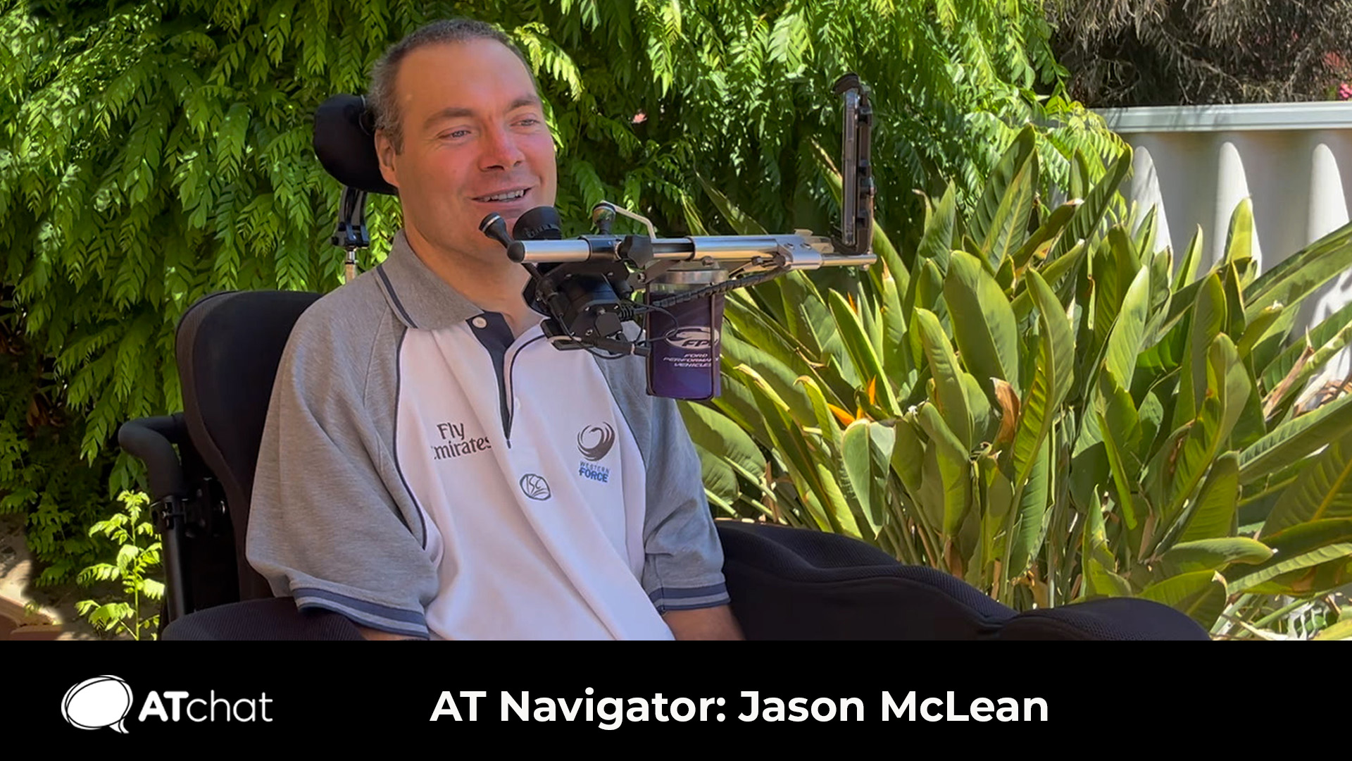 Jason McLean A man sits in his powered chair and smiles off to the right of the camera.