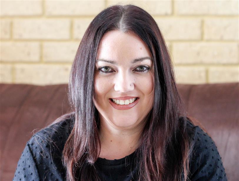 woman with long brown hair smiles at camera