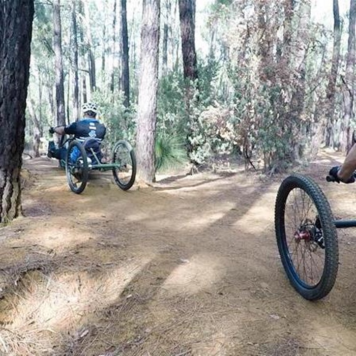 break the boundary action two men ride handcycles through the bush