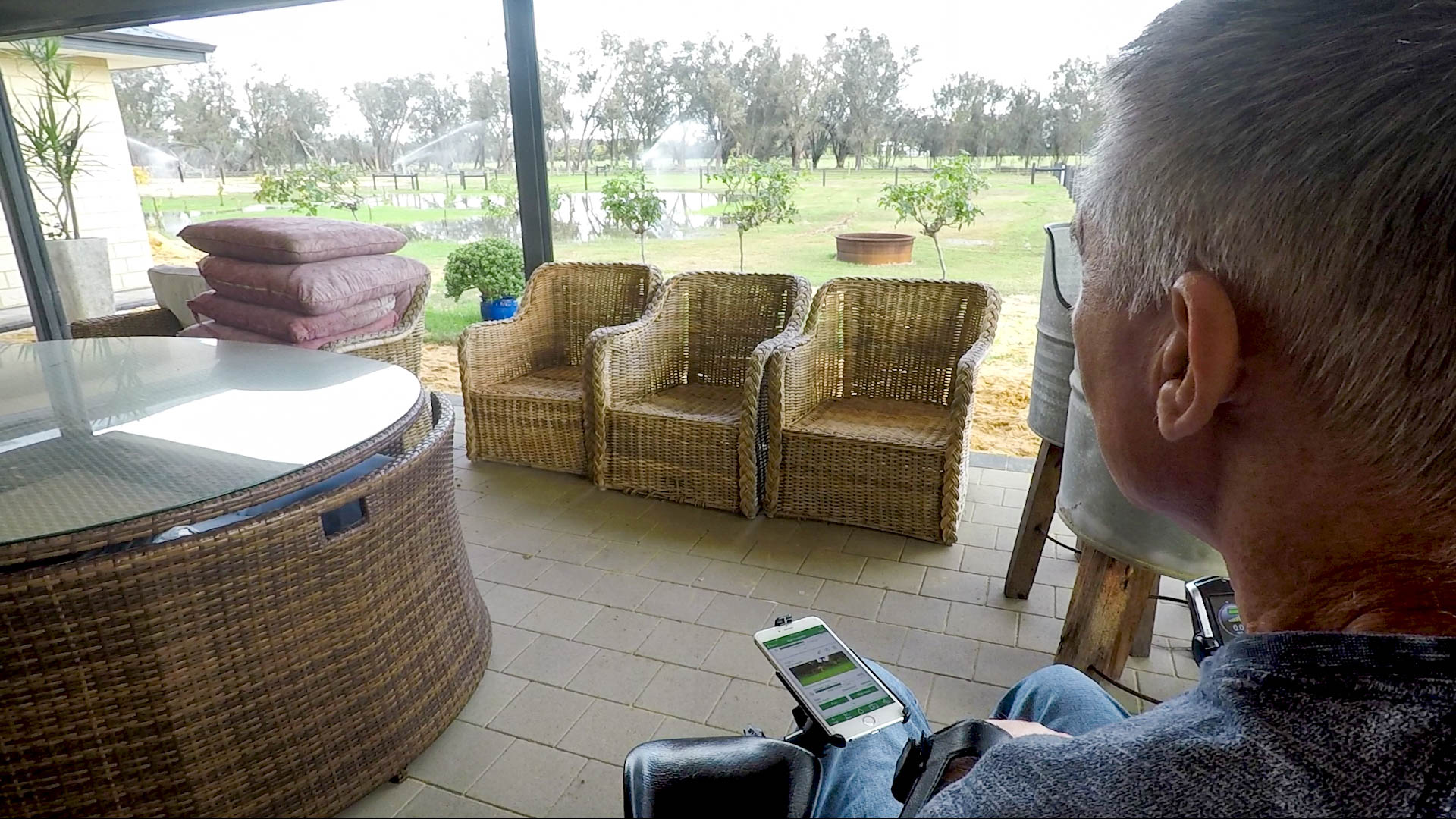 Gary on his porch Gary sits on his porch looking out at his property as he operates his retic system from his device.