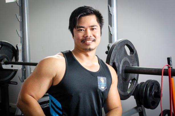 A muscular man smiles in the gym from a wheelchair. A muscular man smiles in the gym from a wheelchair.