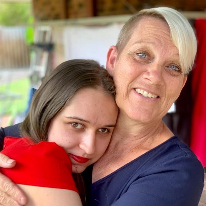 ness hugging friend woman in red hugs taller blonde woman