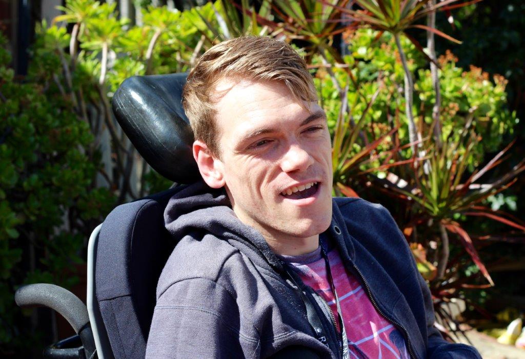 A man in a wheelchair smiles