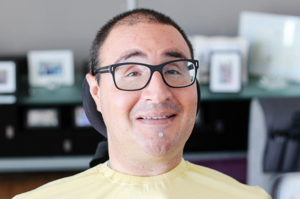 man wearing glasses smiles