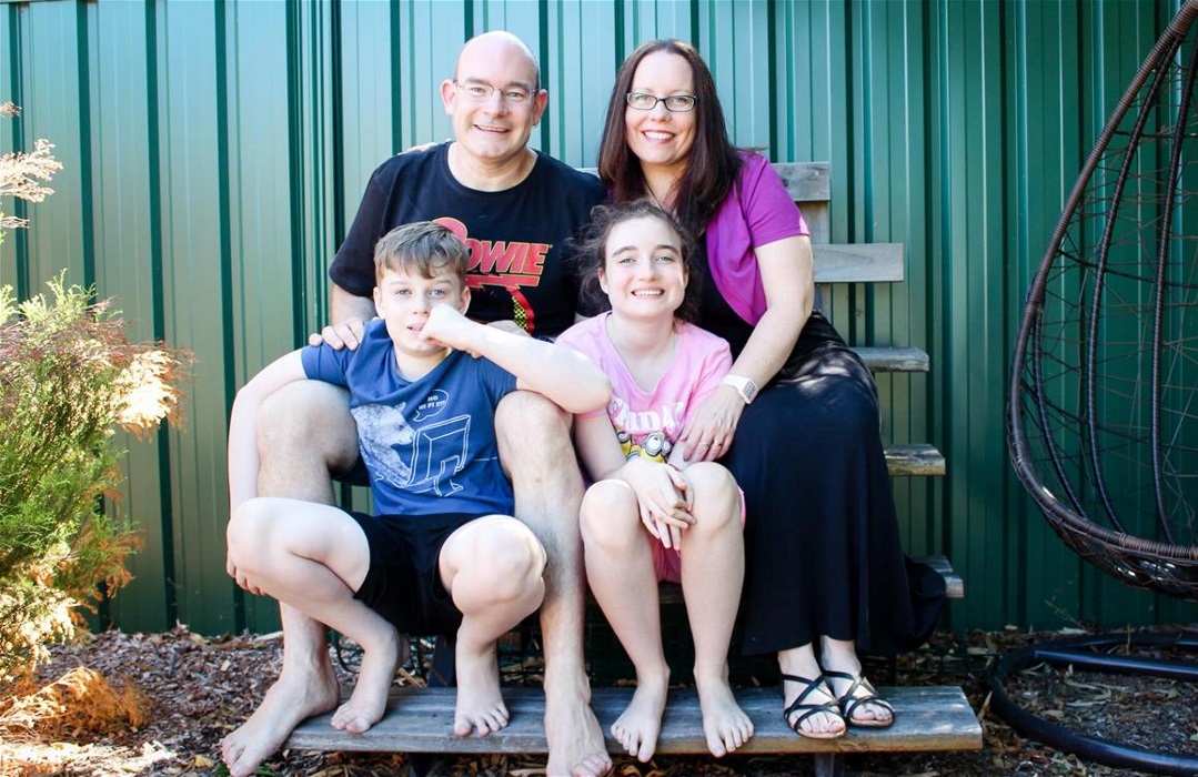 The Bolger family The four members of the Bolger family are seated outside on a wooden seat smiling at the camera