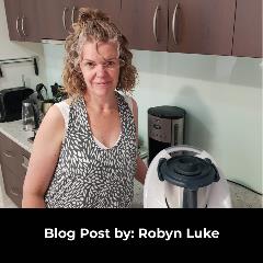 Lady wearing a black and white patterned dress standing next to her Thermomix