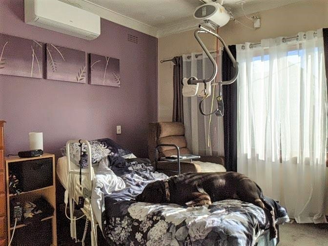 Dy's bed and hoist, with her dog on the bed. Dy's bed and hoist, with her dog on the bed.