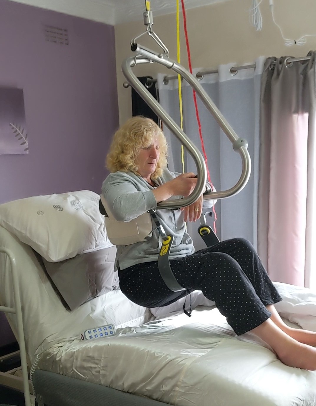 Dy uses a hoist to get into her bed. Dy uses a hoist to get into her bed.