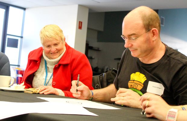 A woman and a man work on a written document