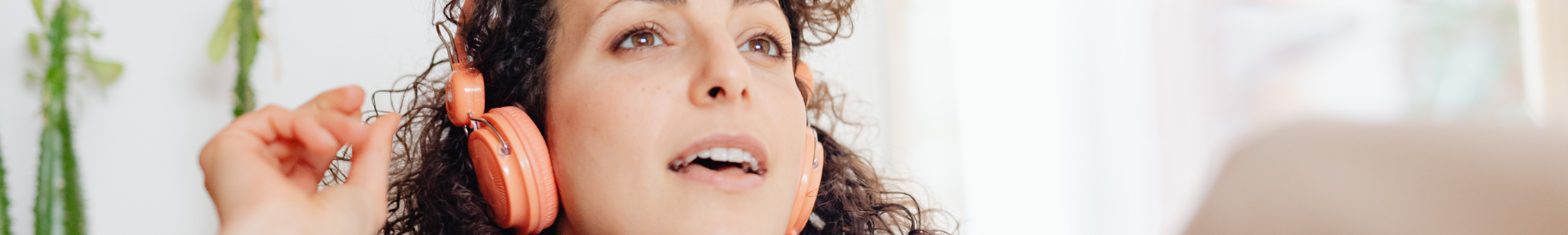 a photo of a women with headphones looking up and singing