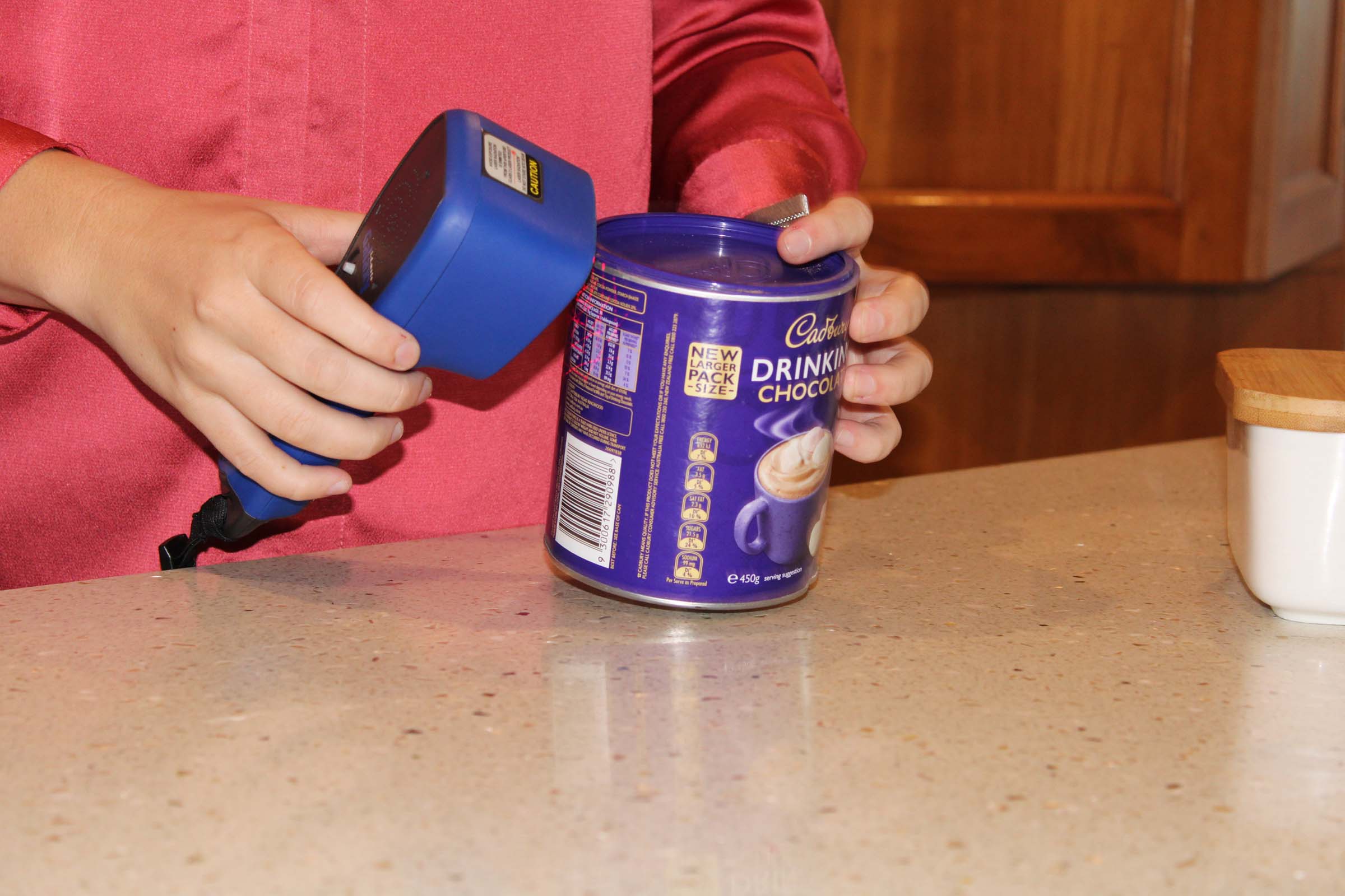 A close up shot of a scanner scanning a tin.