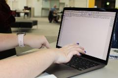 Close up shot of hands typing on a computer.