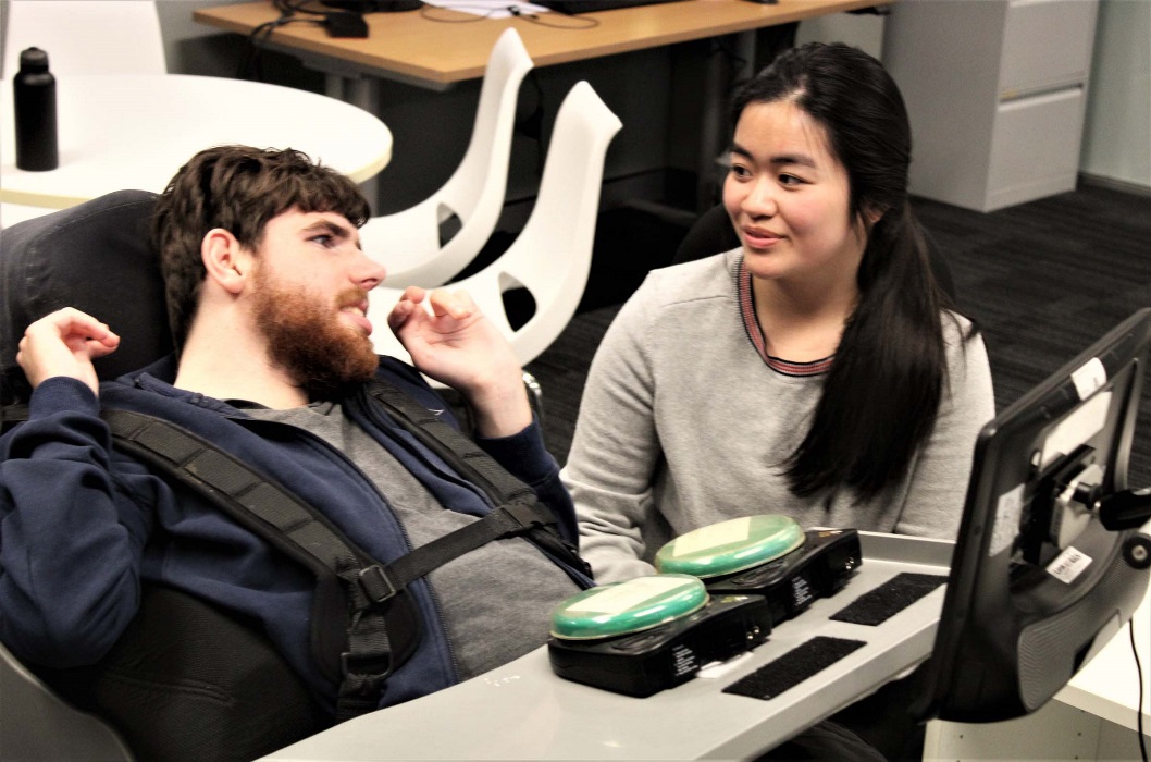 A man and a lady work together at an adapted work station. A man and a lady work together at an adapted work station.