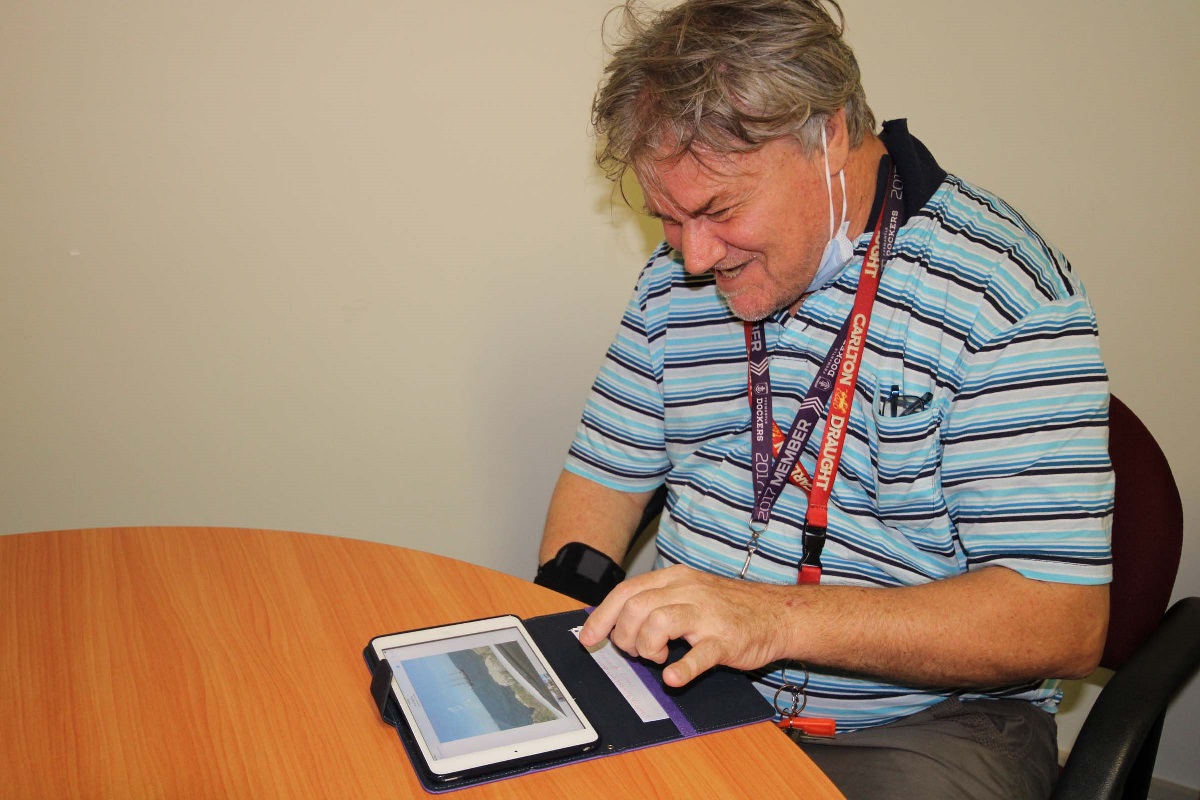 A man joyfully works on an iPad. A man joyfully works on an iPad.