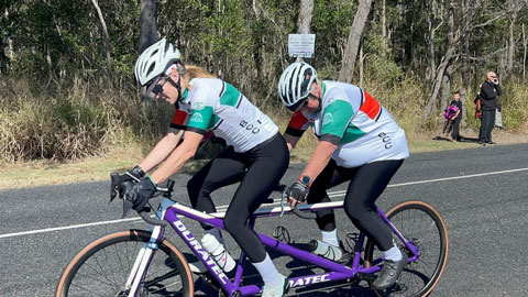 Two women riding a tandem bike