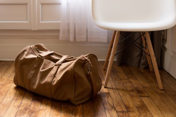A bag sits next to a chair.
