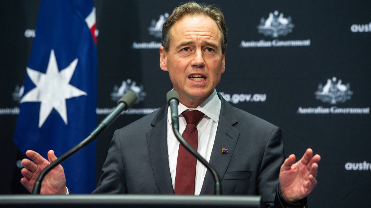 The Hon Greg Hunt MP Minister for Health and Aged Care Picture of a man at a microphone with the Australian flag behind him
