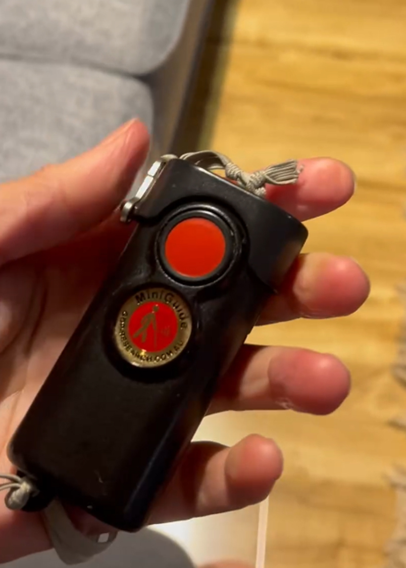 A hand holds a Miniguide