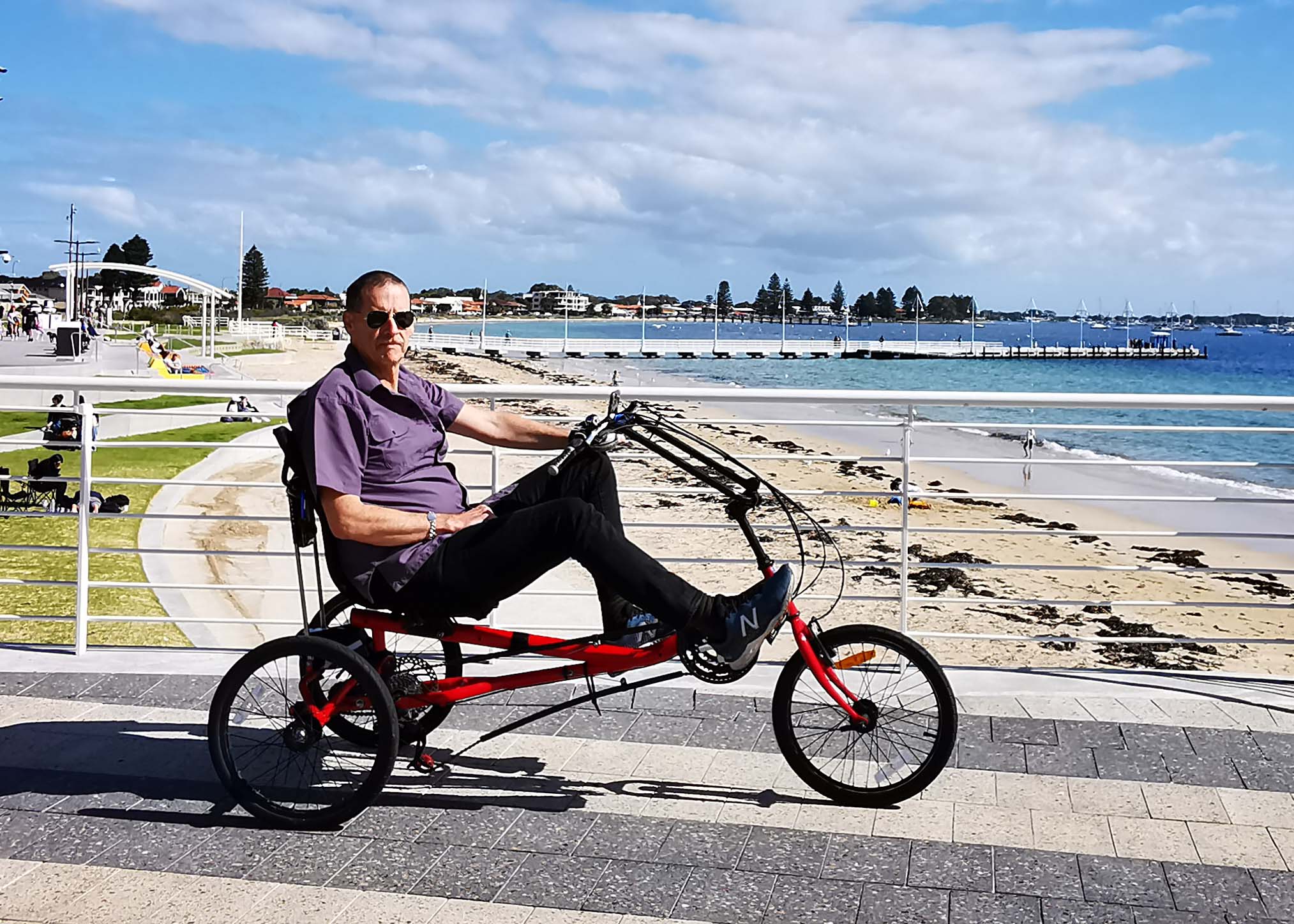 Ian recumbent trike A man is seated on his recumbent trike by the seaside
