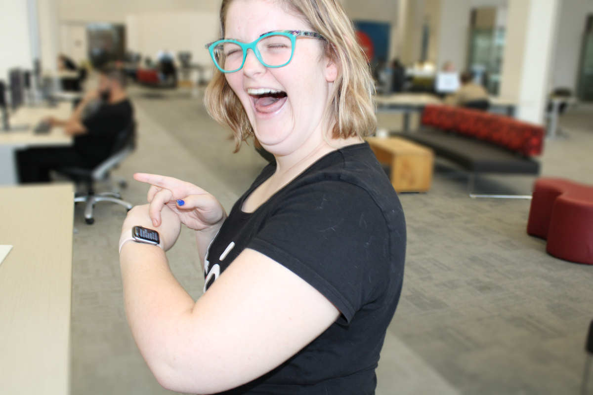 A photo of a lady smiling, checking her smart watch A photo of a lady smiling, checking her smart watch