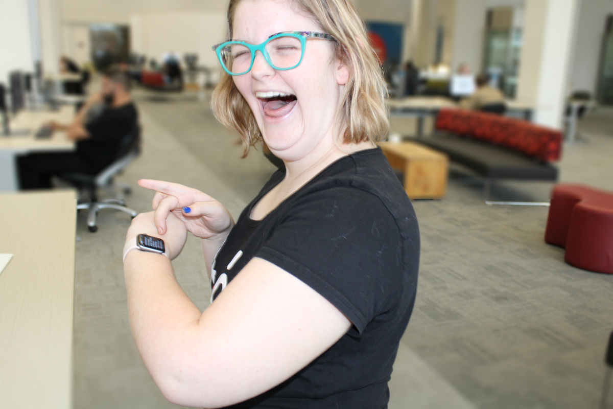 A photo of a lady smiling, checking her smart watch