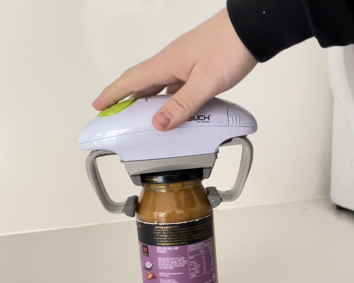 Jayden jar opener A mans hand is rested on top of the One Touch Jar Opener