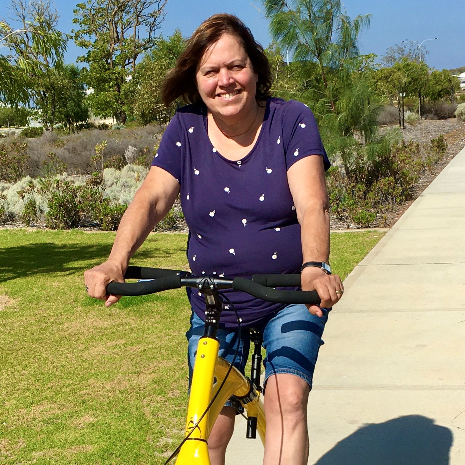 woman sits on yellow walking bike