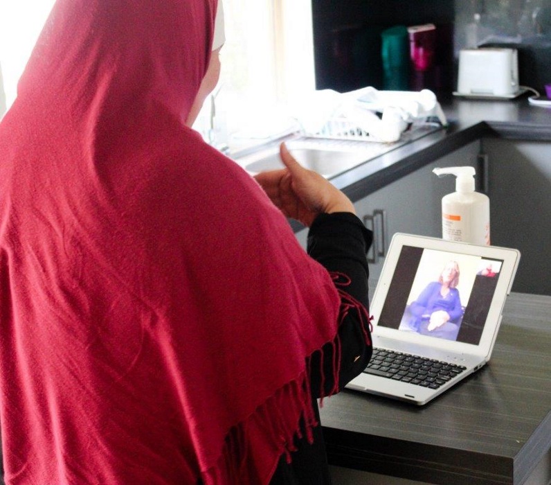 Lady signing to a friend on her laptop