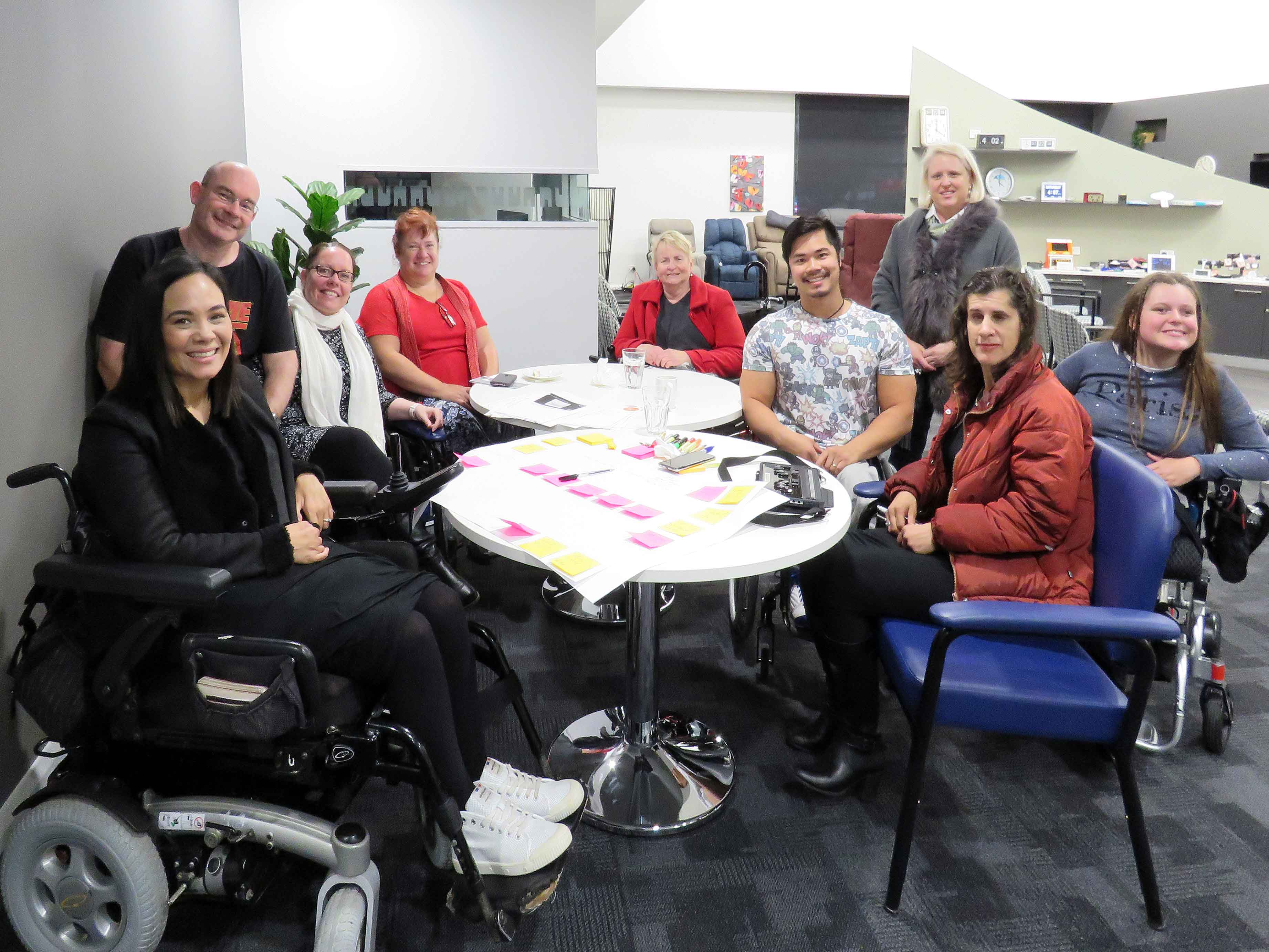 man using power wheelchair with woman and speech bubble sign