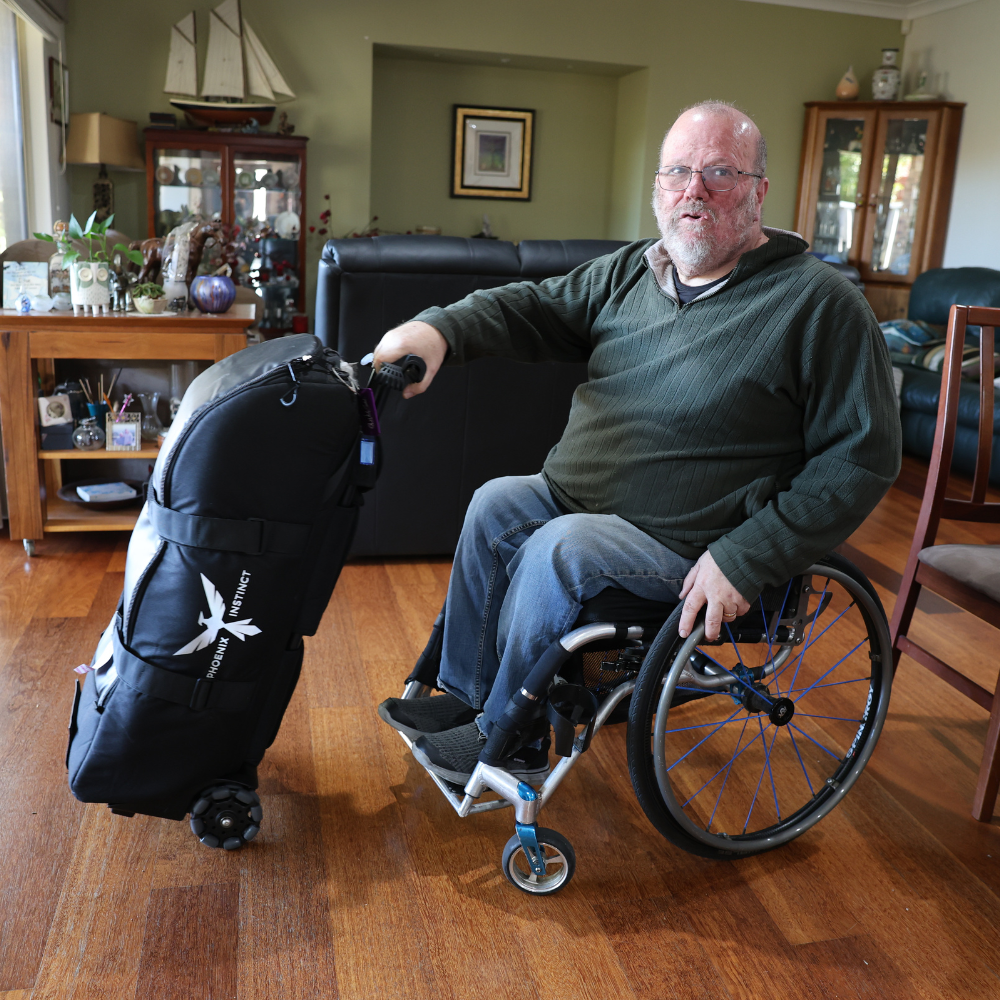 a man in a wheelchair holding a suitcase
