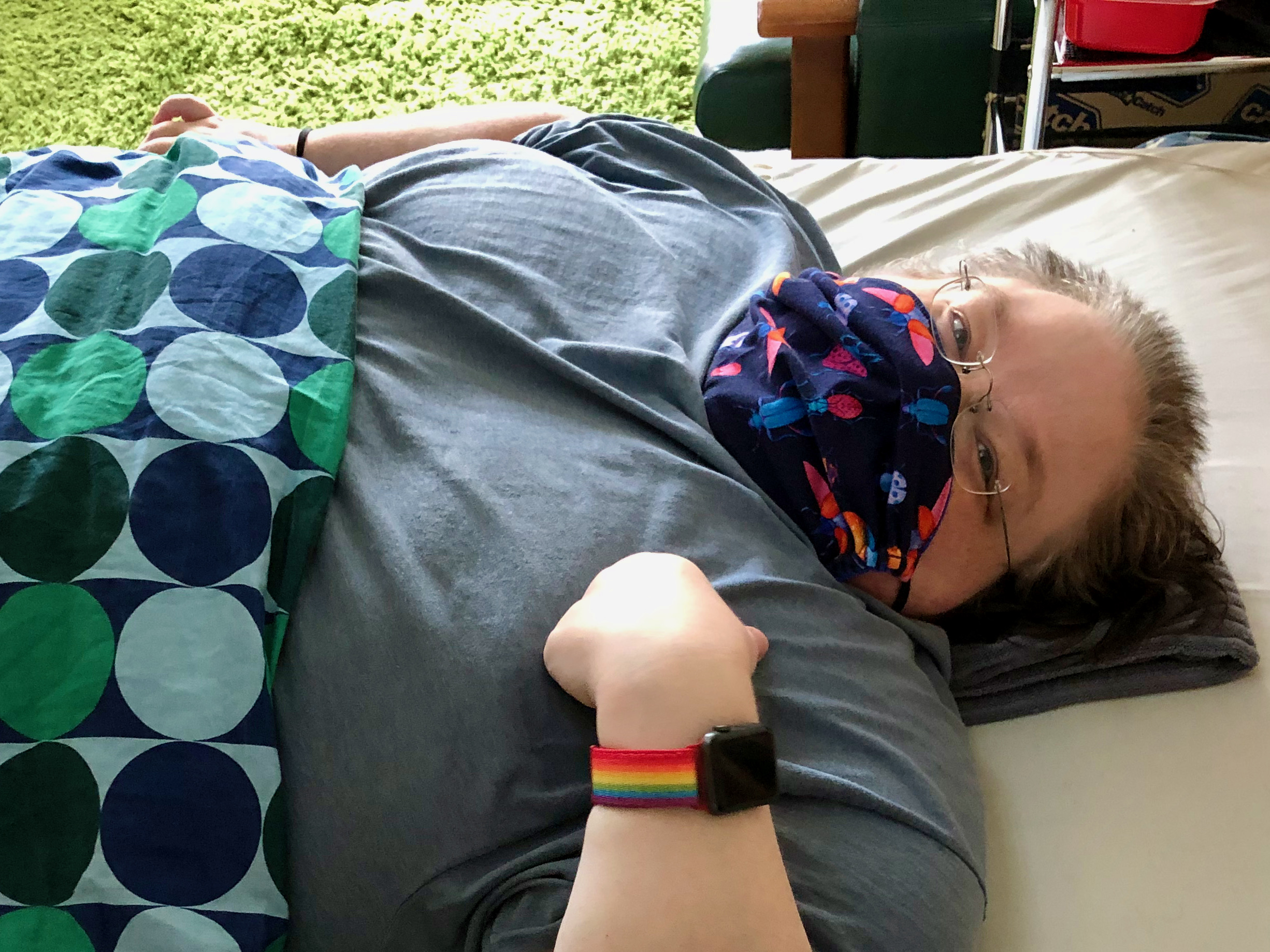 Ricky with colourful mask and blanket on lies in bed. Ricky with colourful mask and blanket on lies in bed.