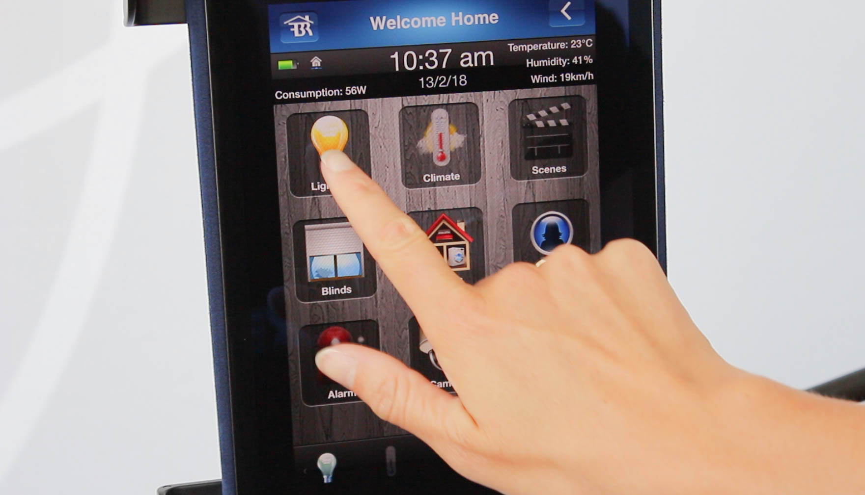 A hand touches a screen for a home automation system A hand touches a screen for a home automation system